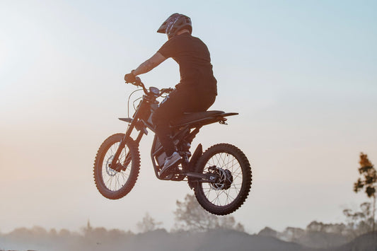 Riding’times GT73 electric motorbike jumping against a sunset sky
