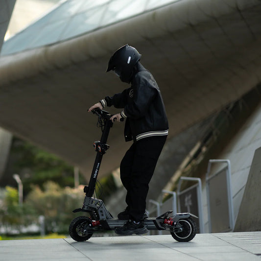 Person riding a scooter in an urban setting with modern architecture.