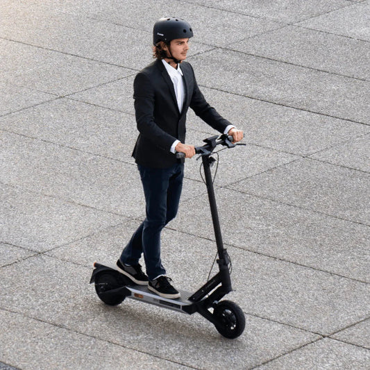 Person riding an electric scooter on a paved surface