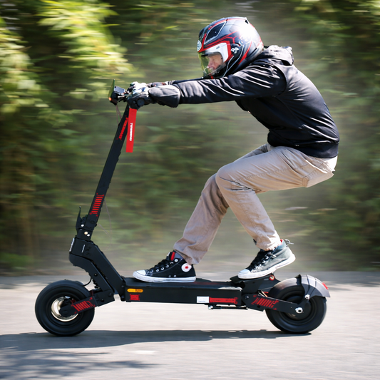 Person riding a black electric scooter on a road with greenery in the background