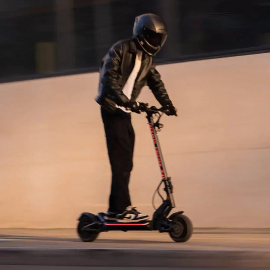 Person riding an electric scooter at night with a blurred background