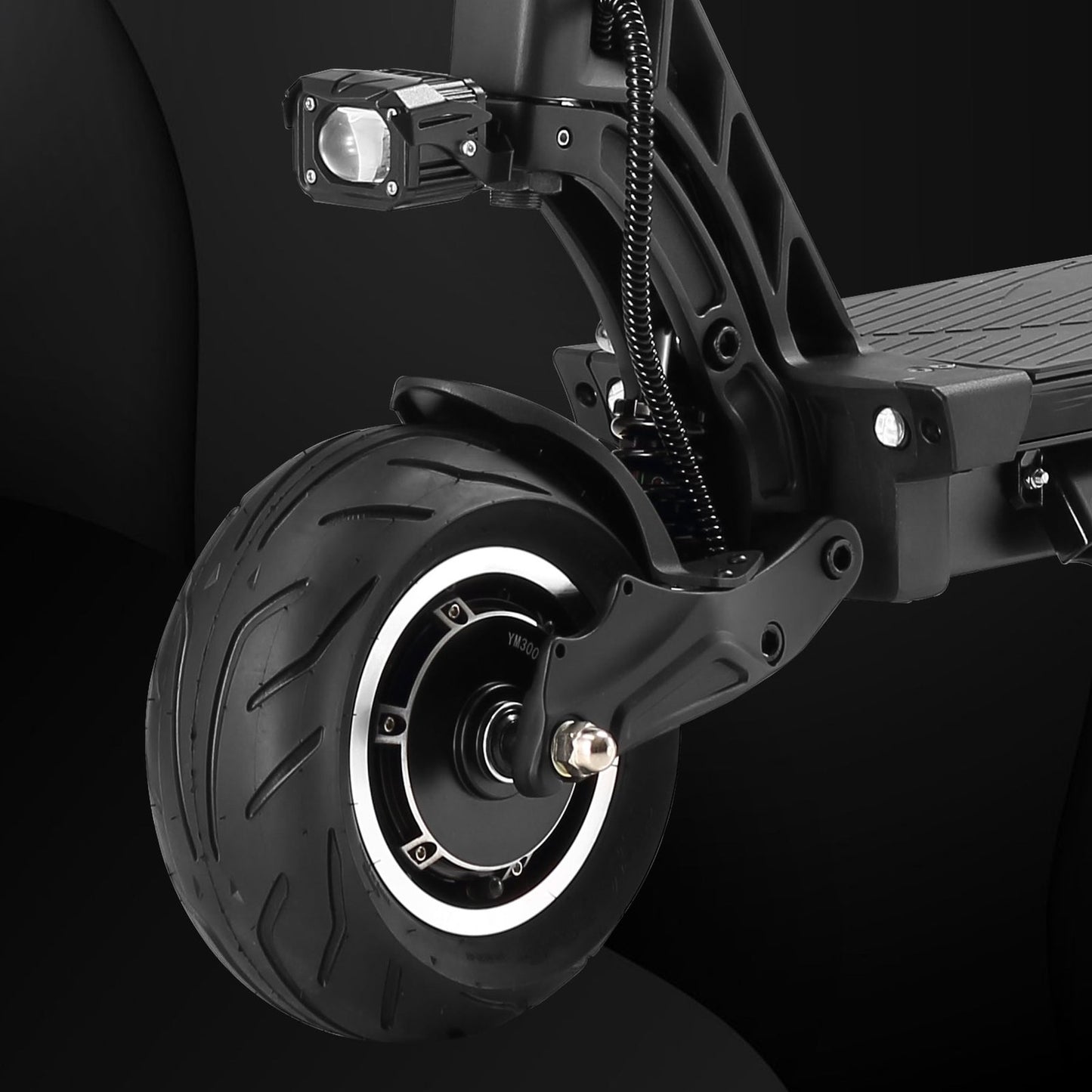 Close-up of a scooter wheel and suspension system on a black background