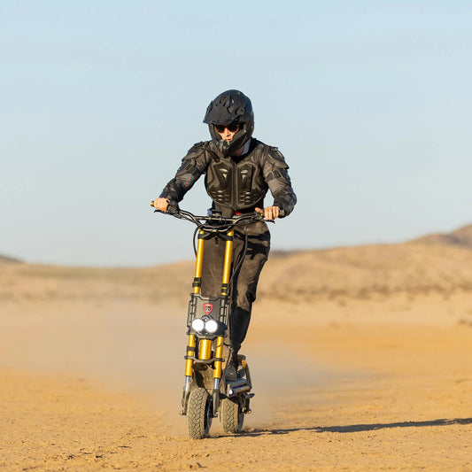 Person riding a electric scooter in the desert with a clear sky