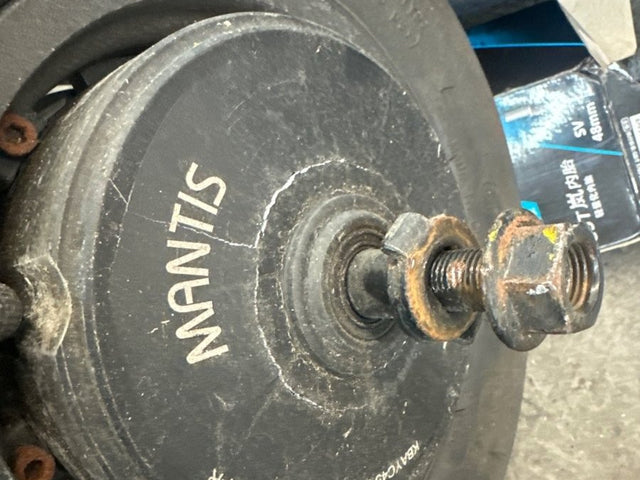 Electric scooter hub motor wheel with the tire off at a Wilson's repair shop
