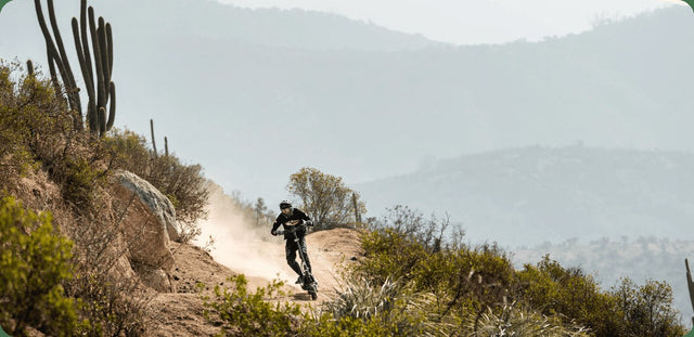 Rider on a Nami Burn-E electric scooter heading down a desert trail