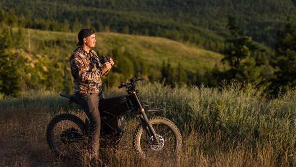 Rider with a Riding'times GT73 Pro electric motorbike in a field at sunset