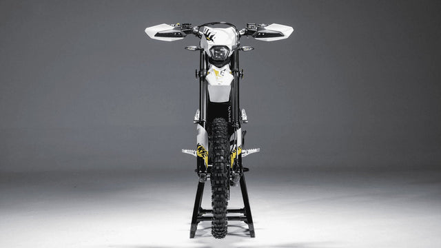 Surron Ultra Bee electric dirt bike on a stand, studio front view