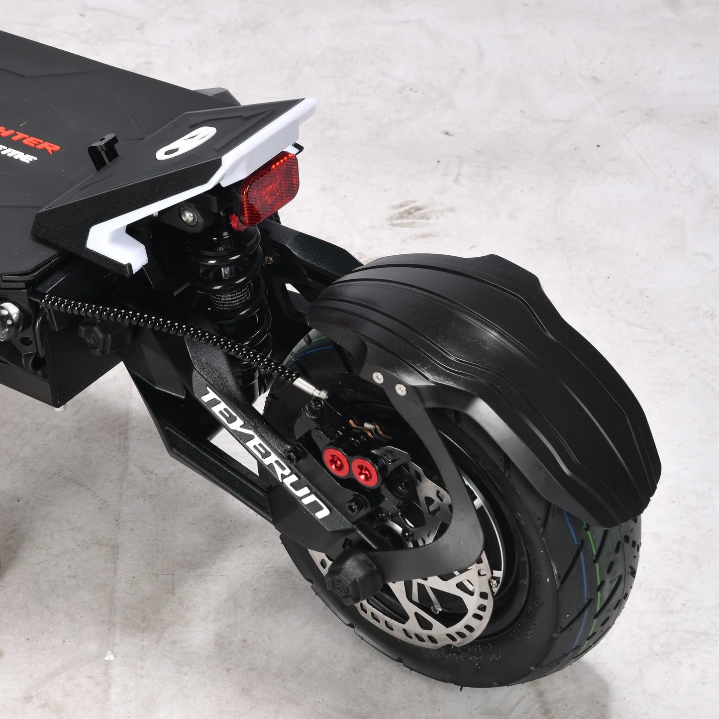 Close-up of a black scooter with visible branding on a light gray background