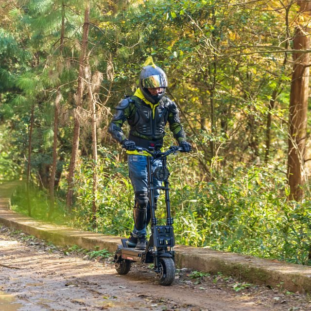 Person riding an electric scooter on a forest path