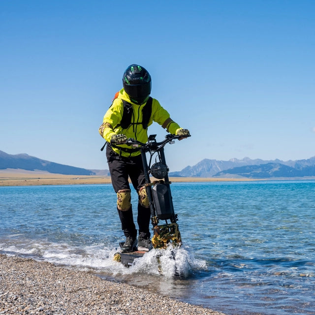 Person riding a hoverboard on a beach with mountains in the background