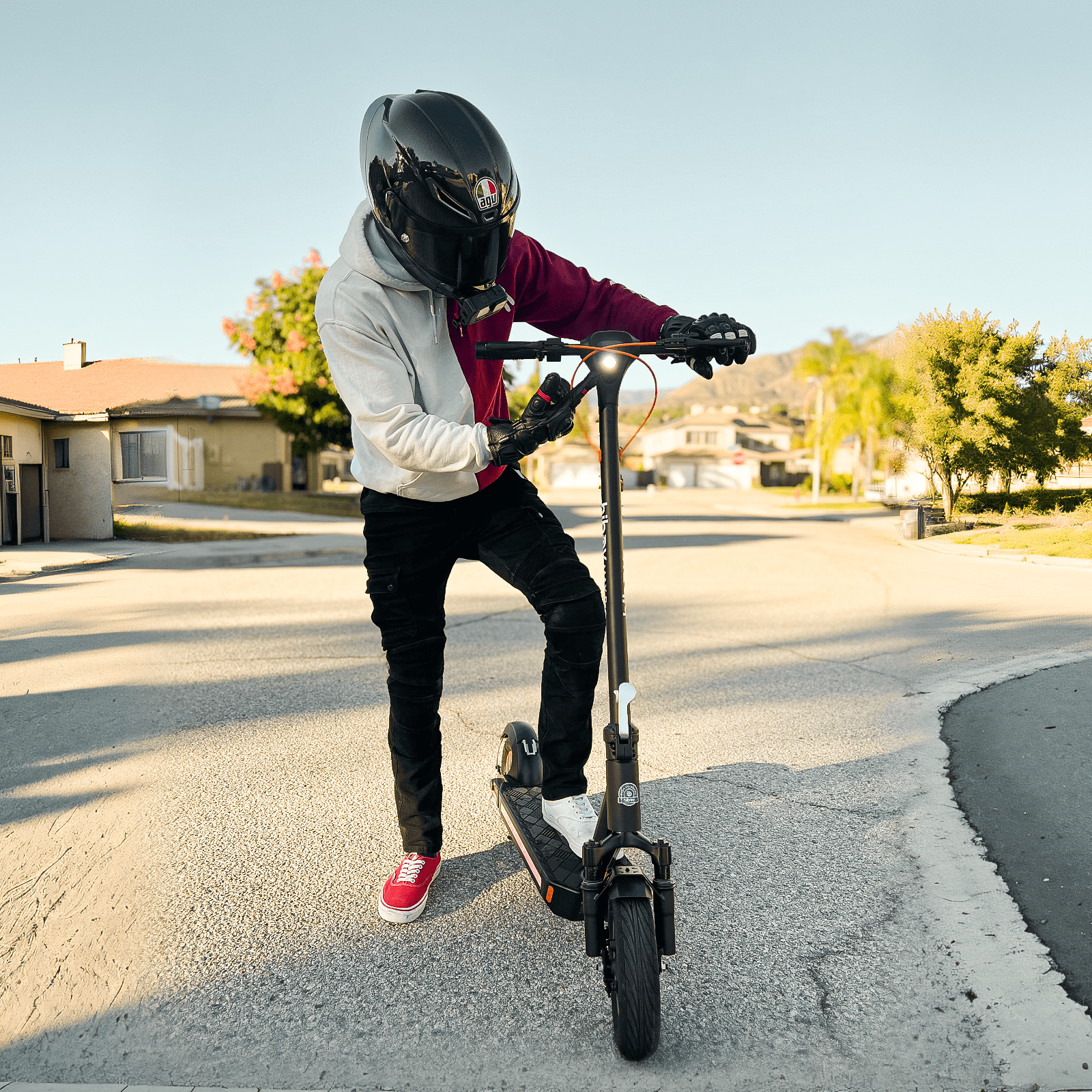 Person riding an electric scooter on a residential street