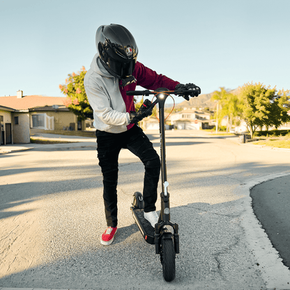 Person riding an electric scooter on a residential street