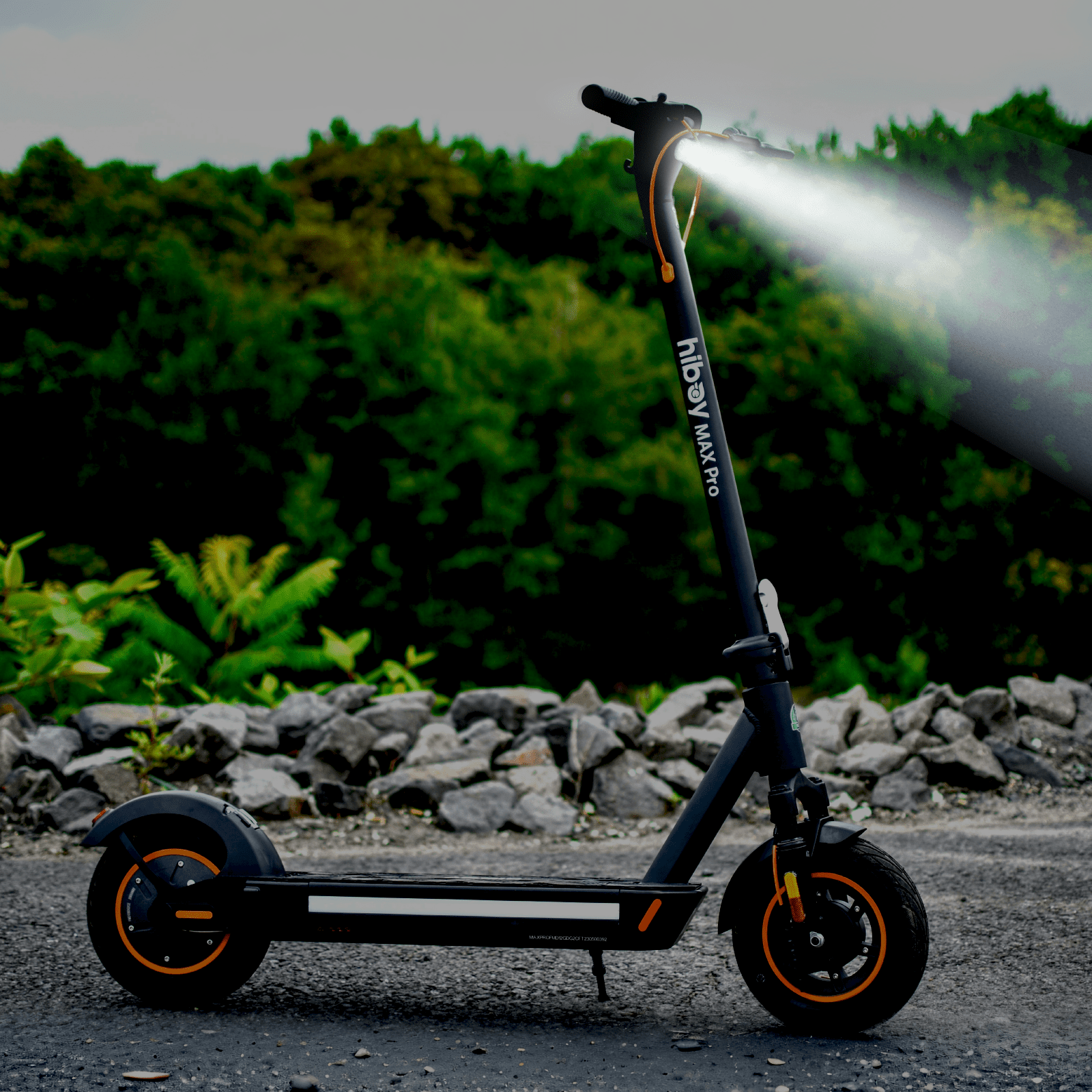 Electric scooter with a light on, parked on a road with greenery in the background