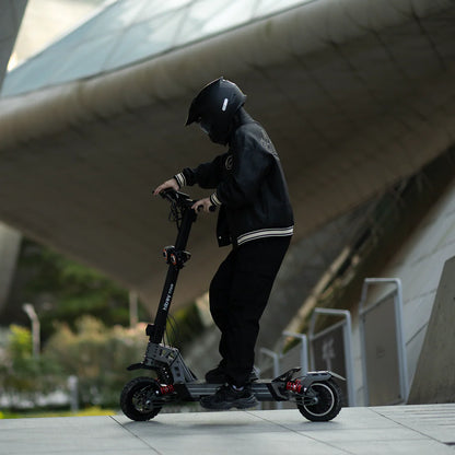 Person riding a scooter in an urban setting with modern architecture.