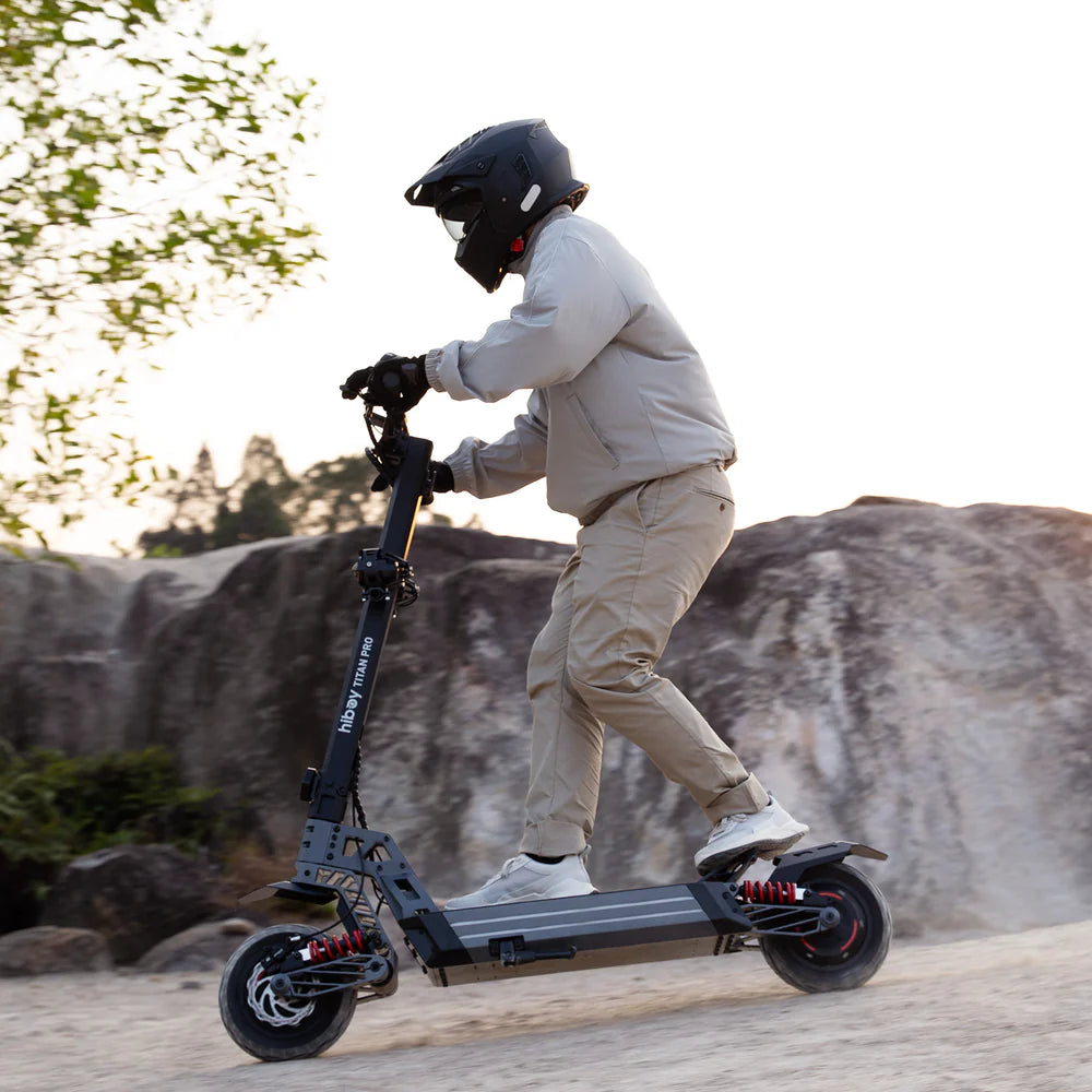 Person riding an electric scooter outdoors with a scenic background
