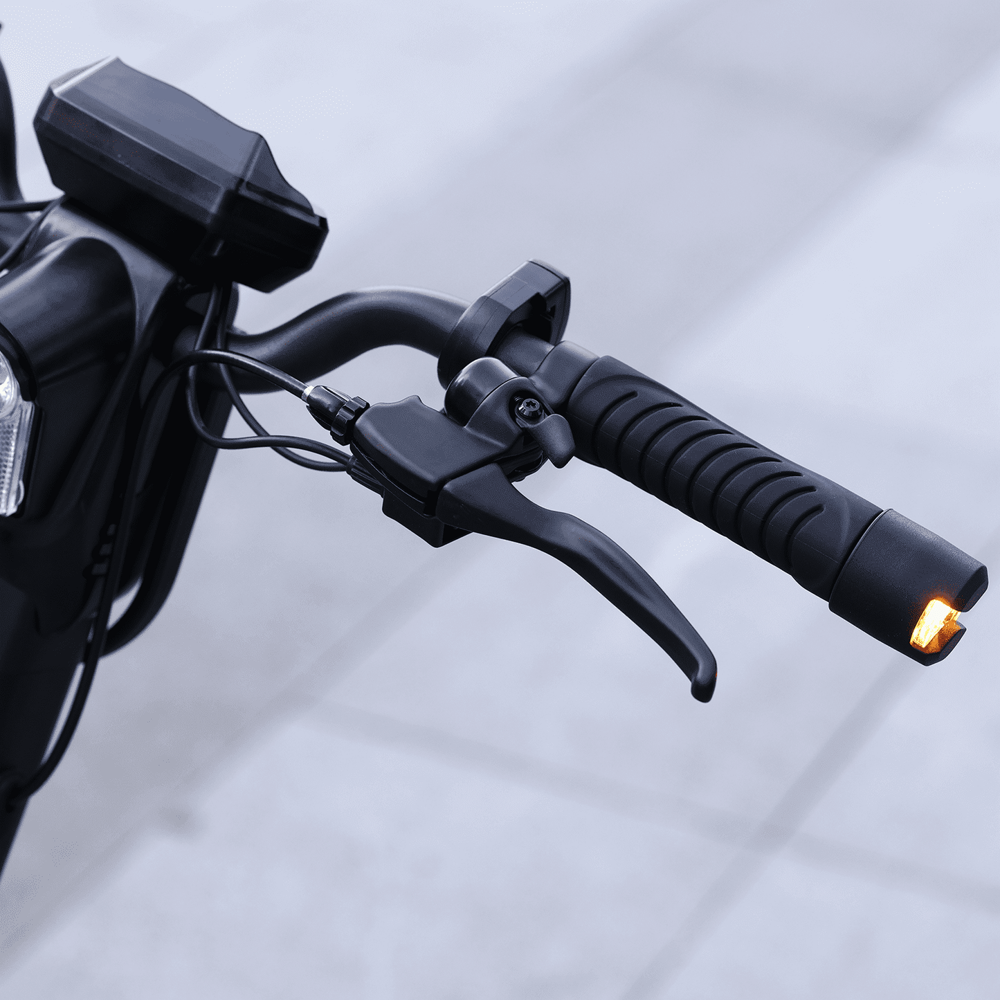 Close-up of motorcycle handlebar with brake lever and light on a blurred background