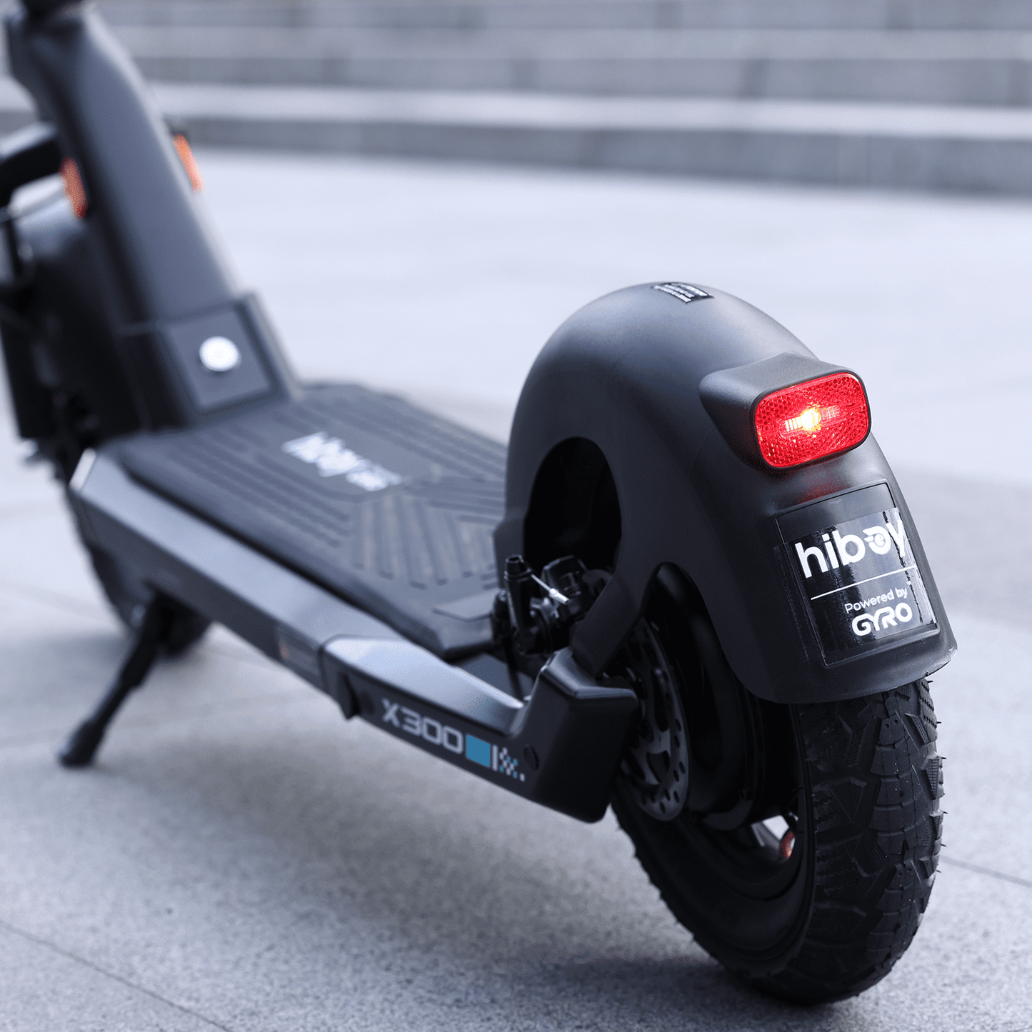 Close-up of a black electric scooter with visible branding on a blurred background