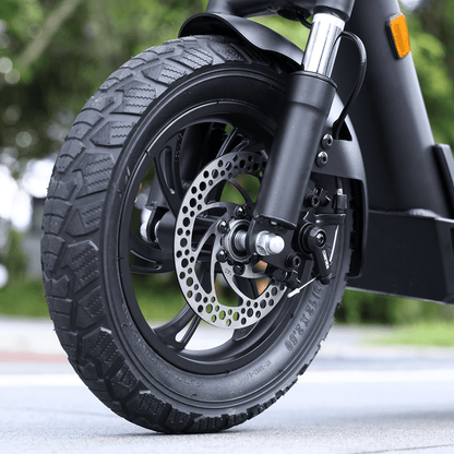 Close-up of a motorcycle wheel with tire and suspension on a blurred background