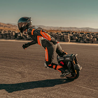 Person riding a unicycle in an open desert area with mountains in the background