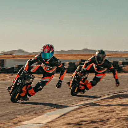 Two motorcyclists racing on a track with a desert landscape in the background