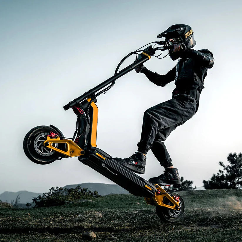Person riding a black and yellow scooter in an outdoor setting