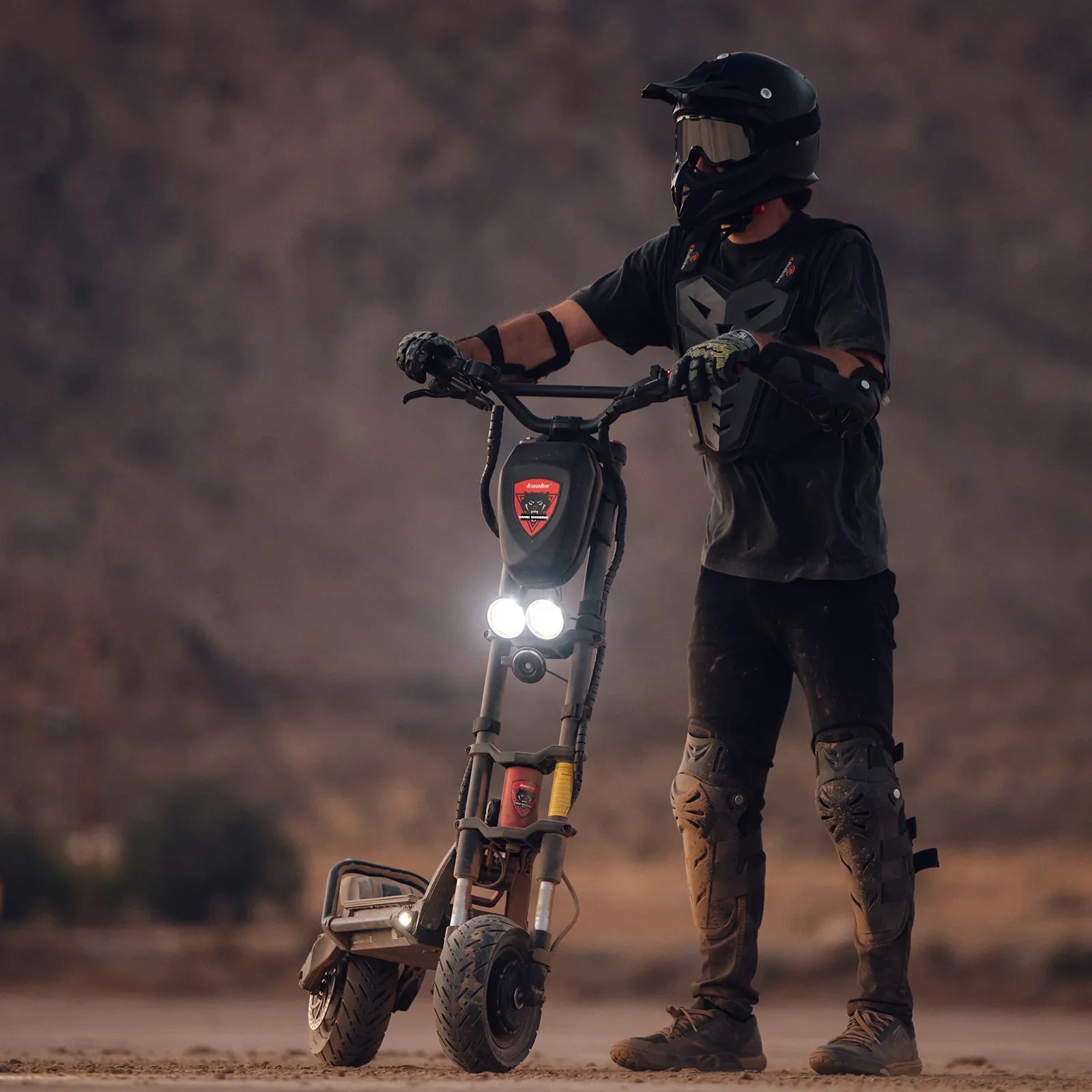 Person on a electric scooter in a desert setting with mountains in the background
