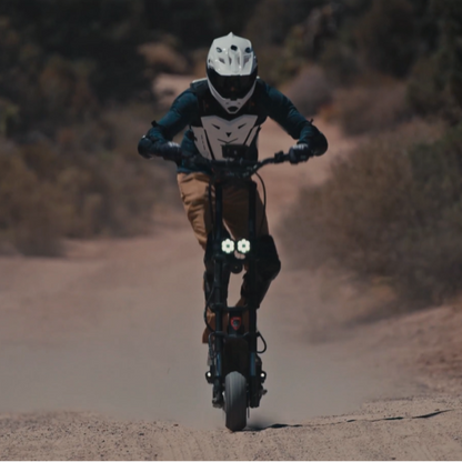 Person riding a bicycle on a dirt road with a blurred background