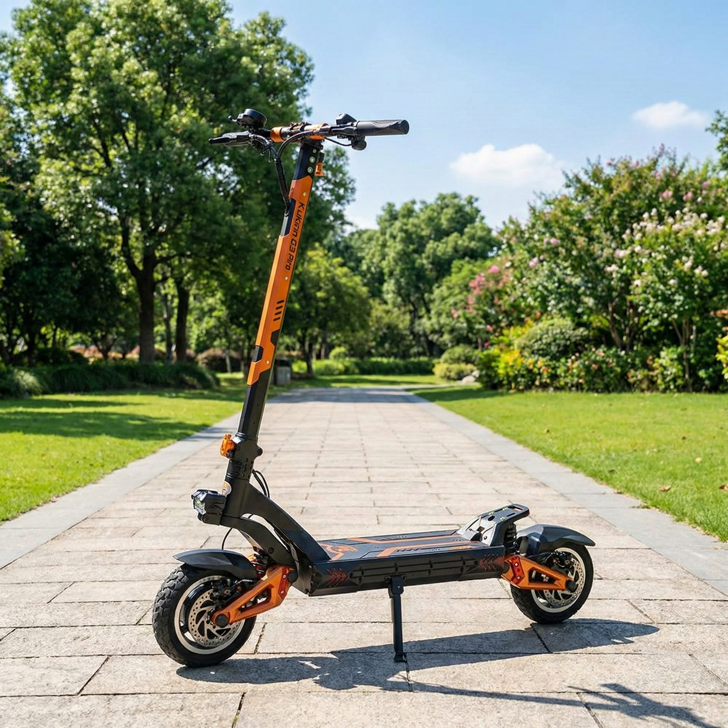Orange and black electric scooter on a paved path with greenery in the background