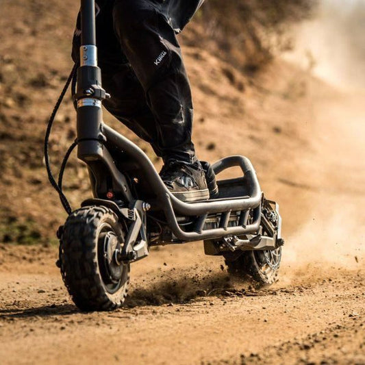 Person riding a dirt bike on a dusty trail