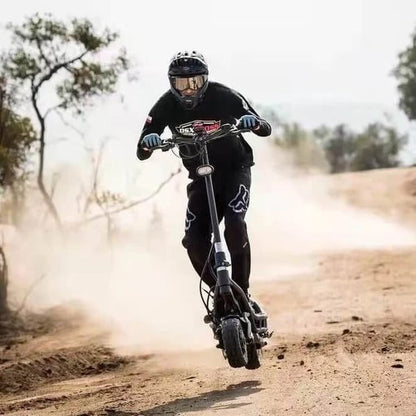 Person riding a scooter on a dirt road with trees in the background
