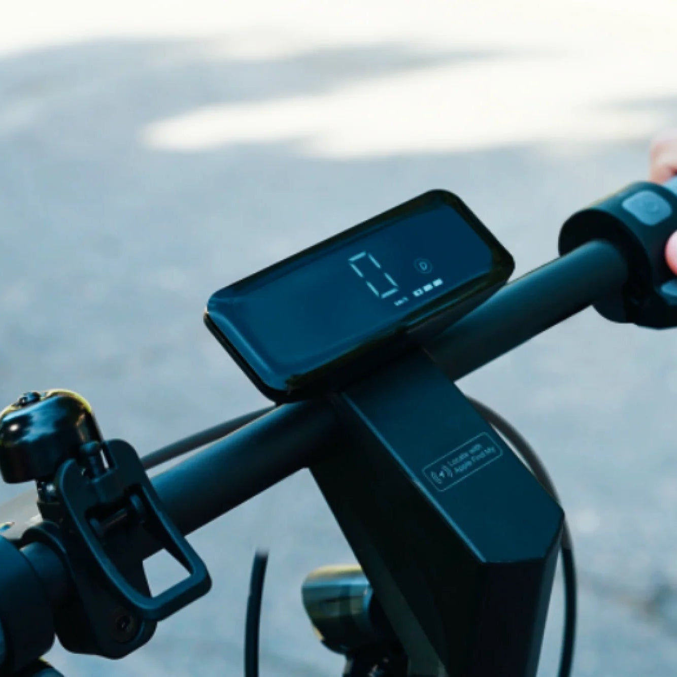 Close-up of an electric scooter handlebar with a digital display and control buttons.