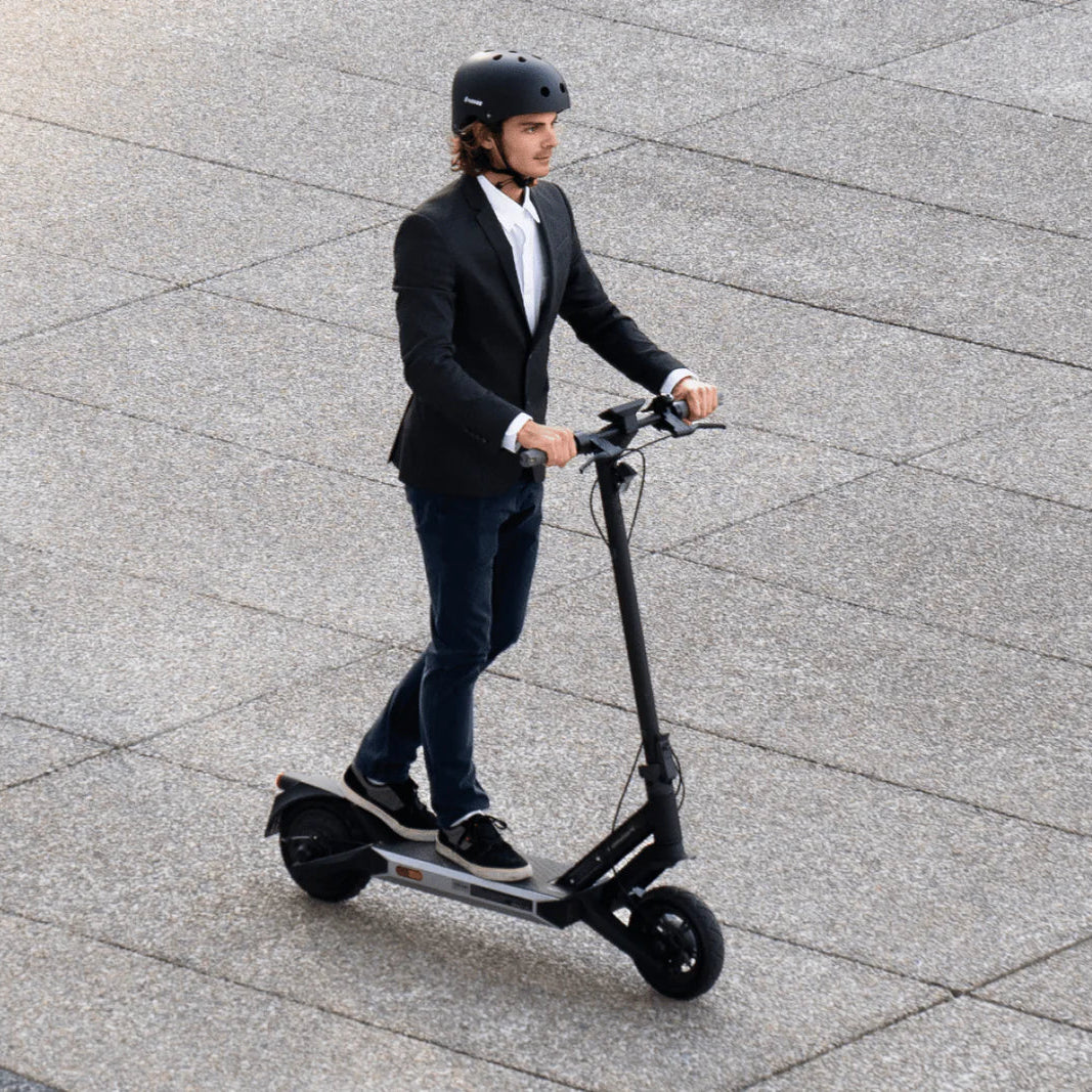 Person riding an electric scooter on a paved surface