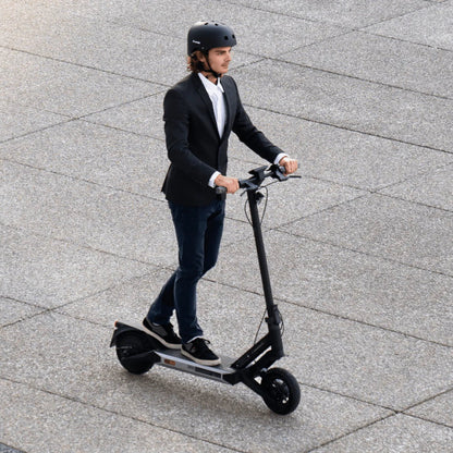 Person riding an electric scooter on a paved surface