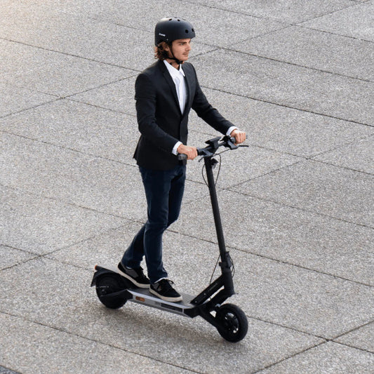 Person riding an electric scooter on a paved surface
