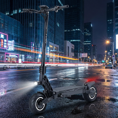Electric scooter on a city street at night with tall buildings in the background
