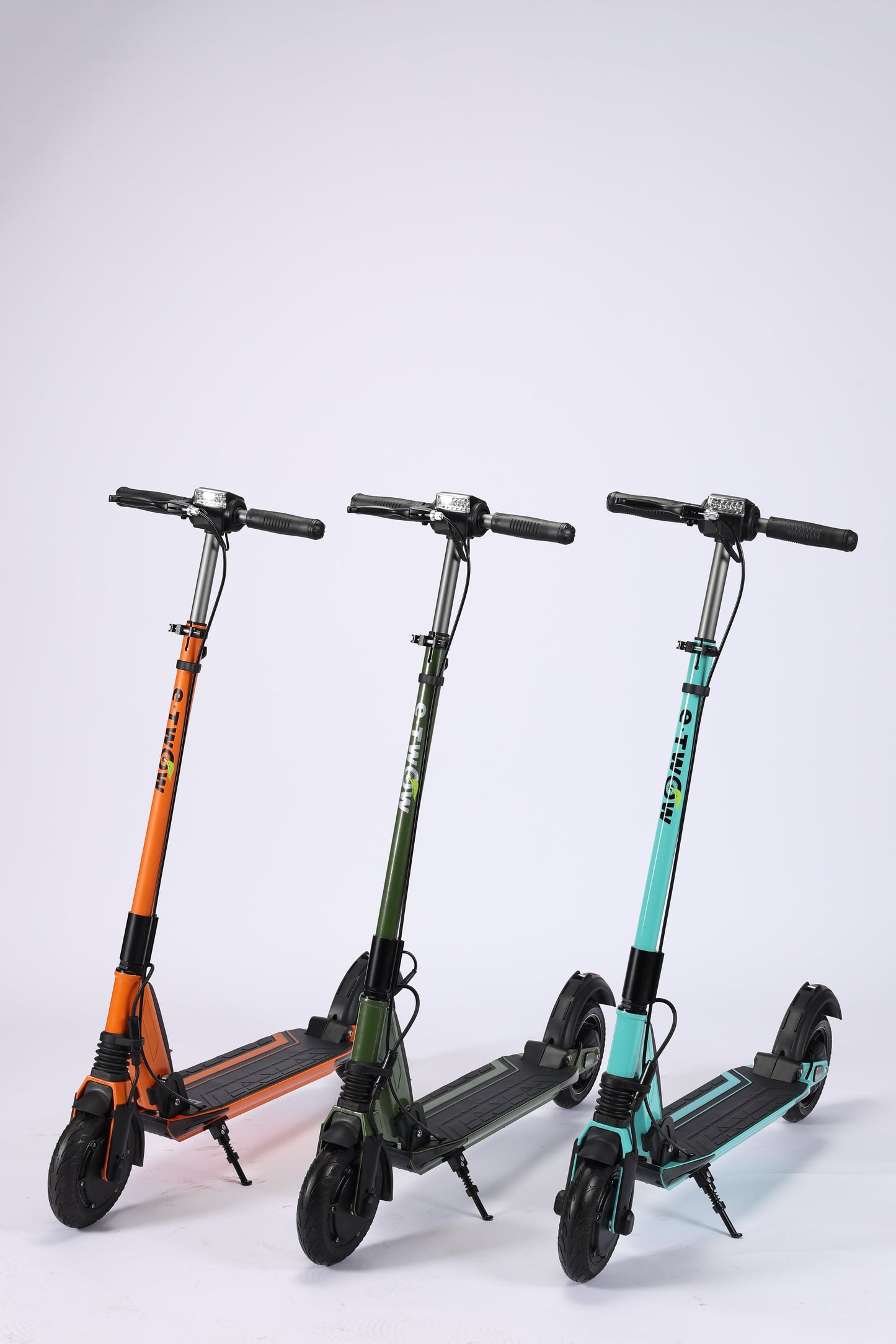 Three folding scooters of different colors on a white background