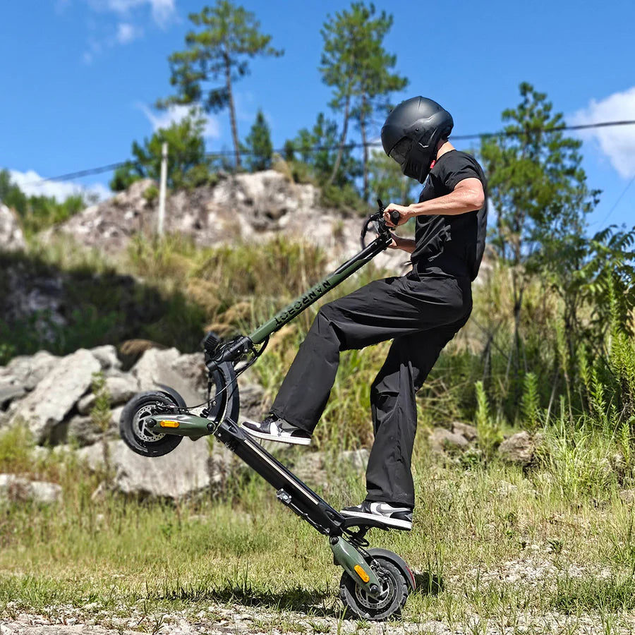 Person riding a black electric scooter in a natural outdoor setting with trees and rocks.