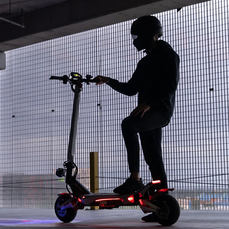 Person riding an electric scooter in a dark setting