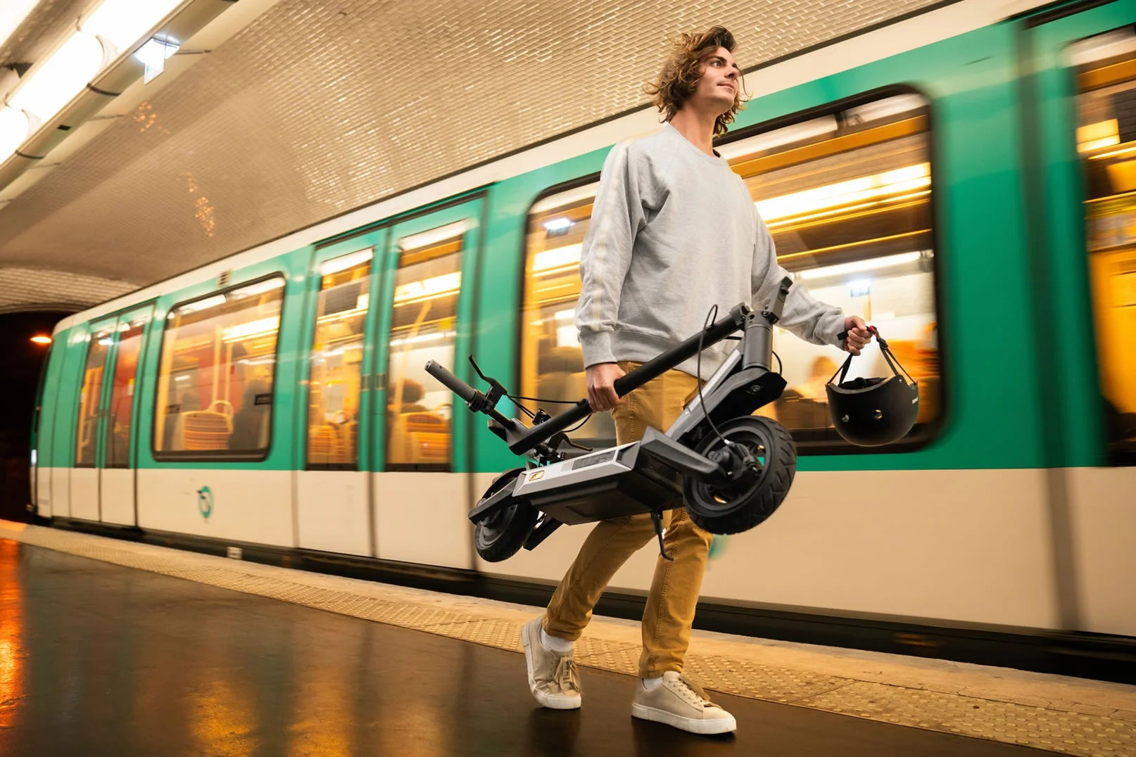 Person with electric scooter in a subway station