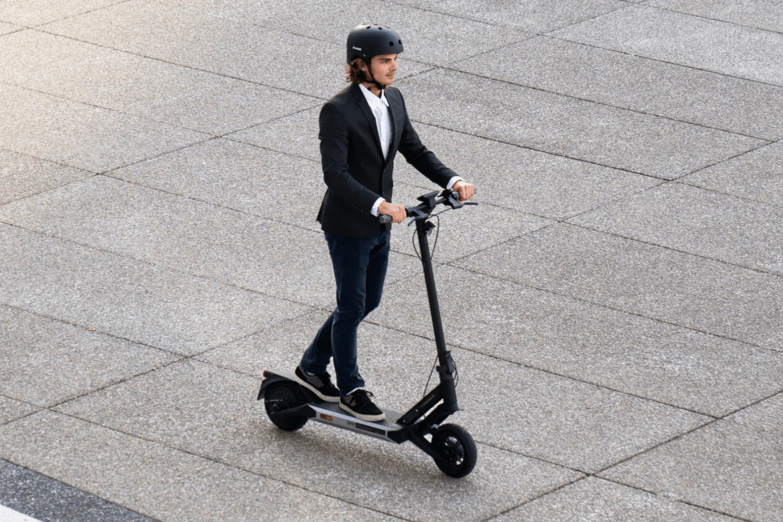 Person riding an electric scooter on a paved surface