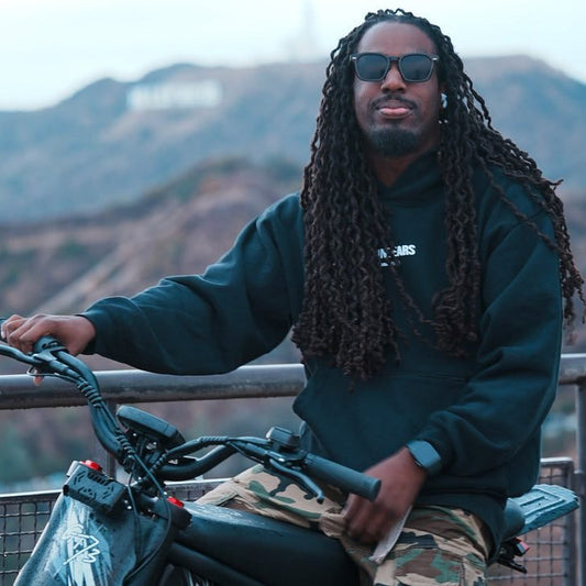 Person sitting on a motorcycle with mountains in the background