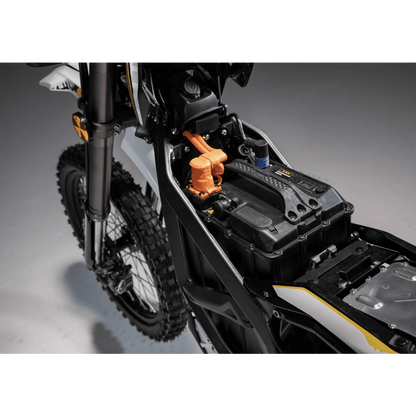 Close-up of a dirt bike's suspension and frame on a gray background